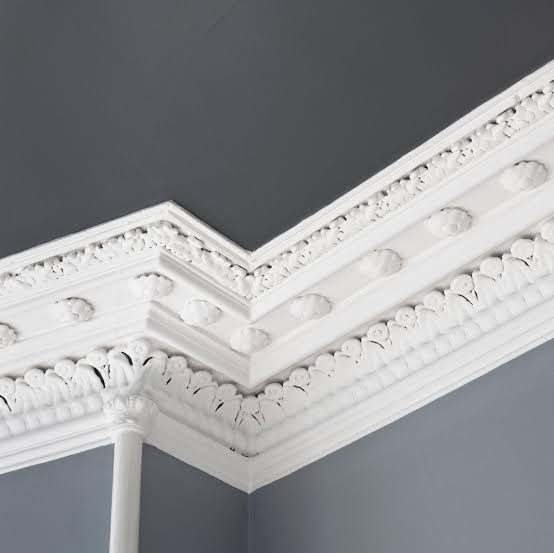 White ornate crown molding against a gray wall